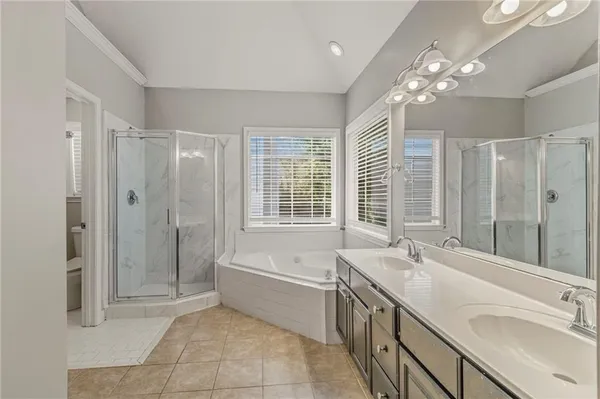 a spacious bathroom with a tub sink shower and mirror