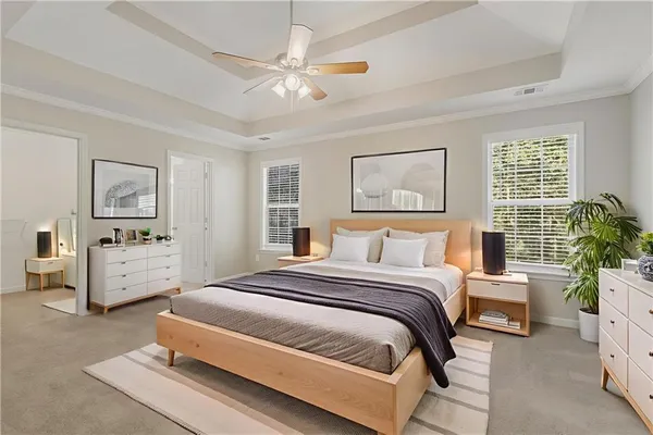 a spacious bedroom with a bed a couch and potted plant