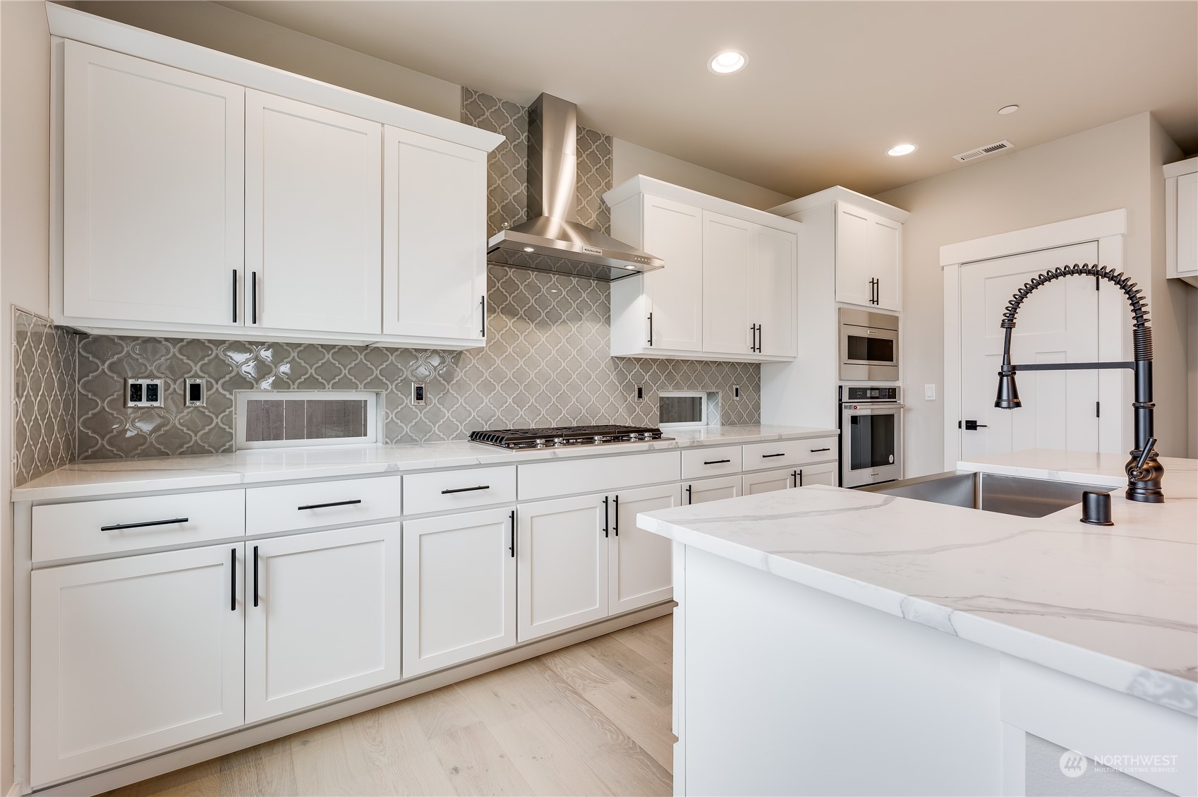 4403 242nd Place Southeast, Unit LOT16 Bothell, WA 98021 - Photo 13 of 27 a kitchen with stainless steel appliances granite countertop a sink a stove and white cabinets
