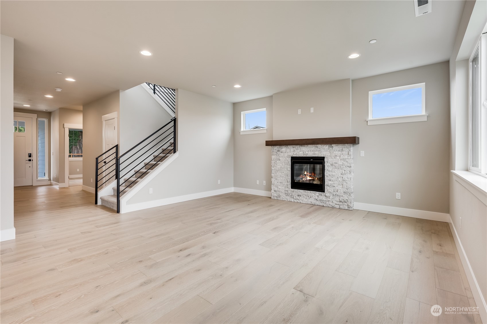 4403 242nd Place Southeast, Unit LOT16 Bothell, WA 98021 - Photo 3 of 27 an empty room with wooden floor fireplace and windows