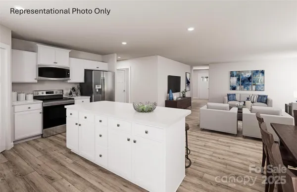 a large white room with kitchen island a flat screen tv and a couch