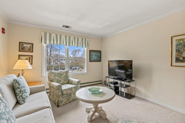 a living room with furniture a flat screen tv and a window