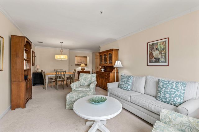 a living room with furniture and a dining table with kitchen view