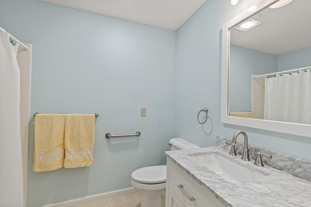 a bathroom with a granite countertop sink a toilet and a mirror