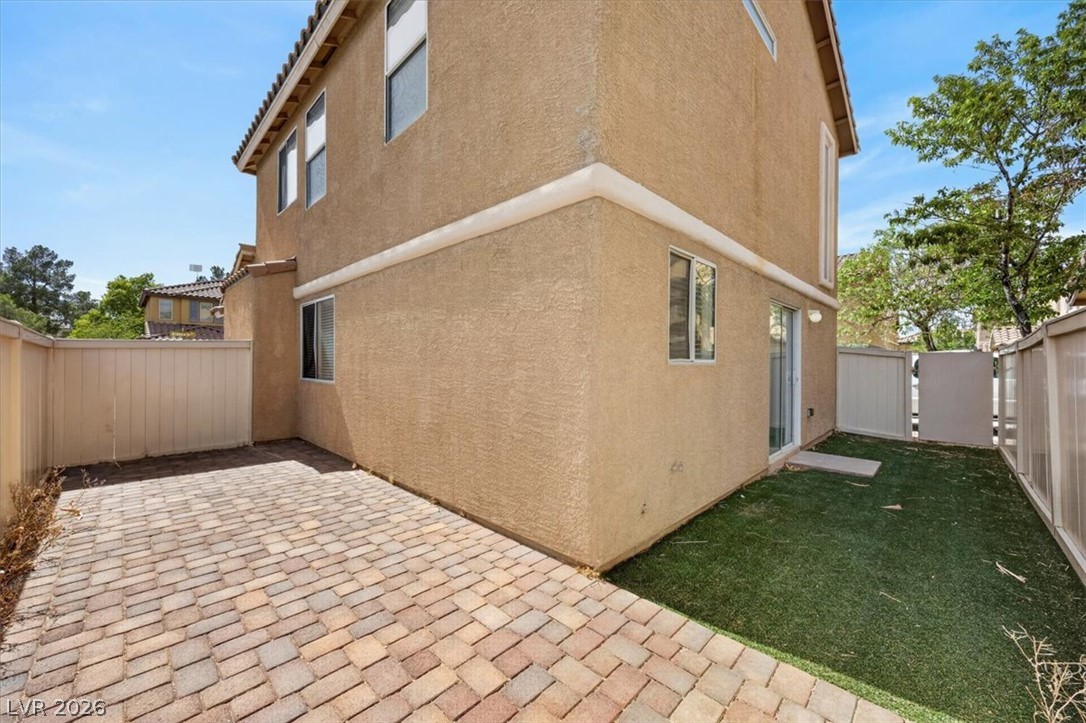 552 Albacate Street Henderson, NV 89015 - Photo 36 of 40 An inviting paved patio transitions to a lush artificial turf area, perfect for outdoor enjoyment.