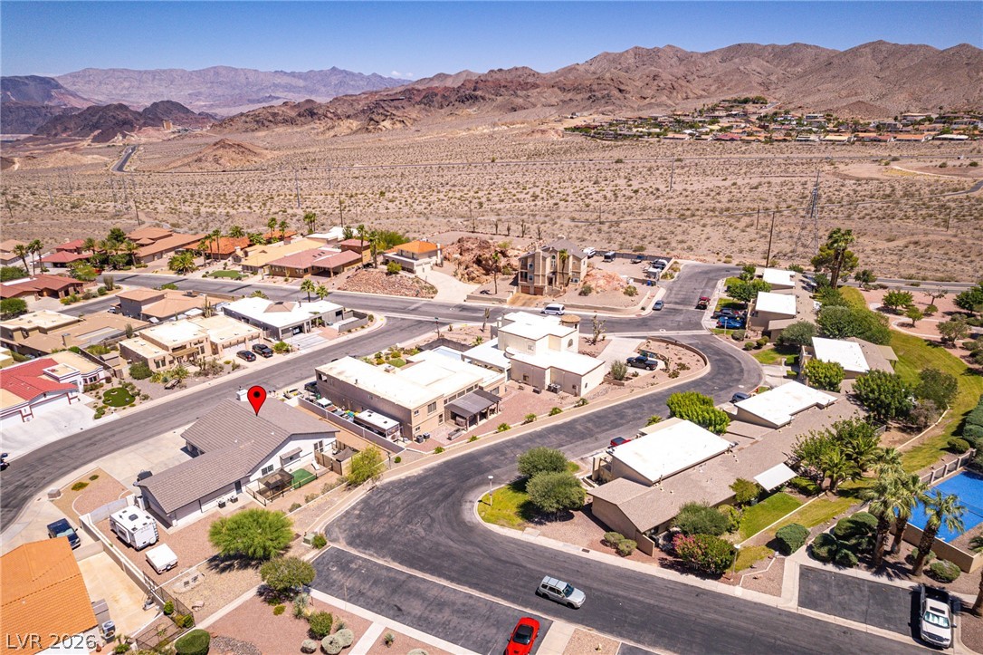 524 Swallow Cove Boulder City, NV 89005 - Photo 54 of 58 An aerial perspective reveals a desert community nestled against a rugged mountain range, featuring a mix of residential structures.