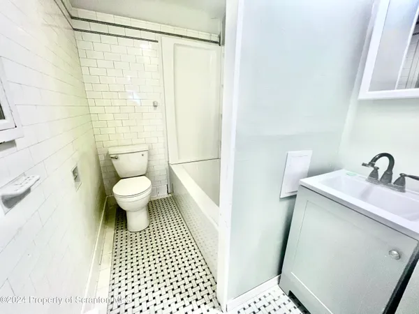 a bathroom with a sink a toilet and a shower