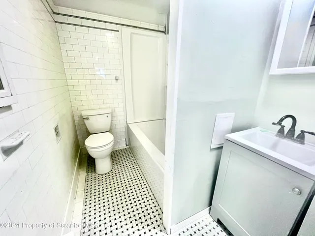 a bathroom with a sink a toilet and a shower