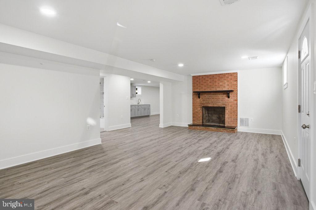 6620 Napoli Road Temple Hills, MD 20748 - Photo 28 of 38 a view of empty room with wooden floor and fireplace