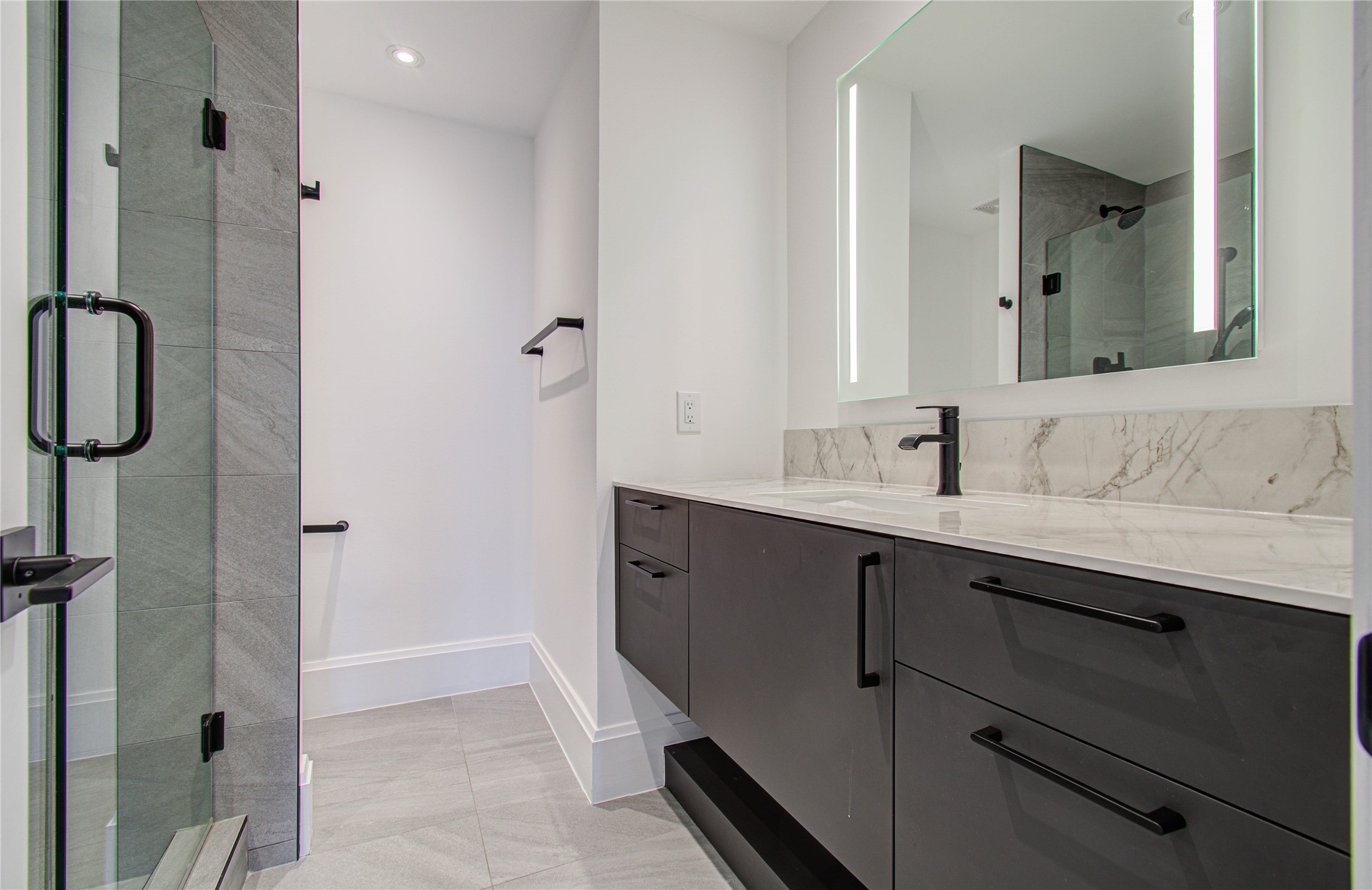 1701 Hermann Drive, Unit 20D Houston, TX 77004 - Photo 15 of 35 a spacious bathroom with a double vanity sink a mirror and shower