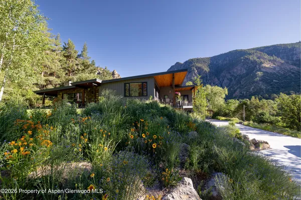 a view of a house with a mountain and a yard