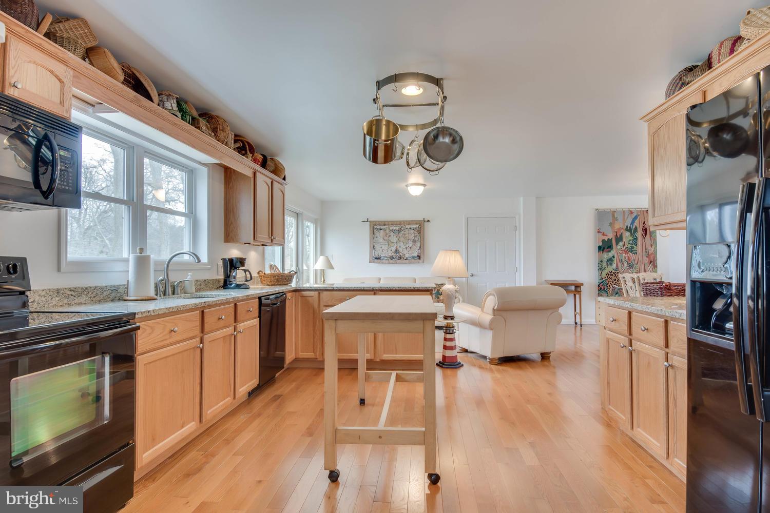 29030 Belchester Road Kennedyville, MD 21645 - Photo 11 of 30 a kitchen with stainless steel appliances granite countertop a stove top oven a sink dishwasher and white cabinets with wooden floor