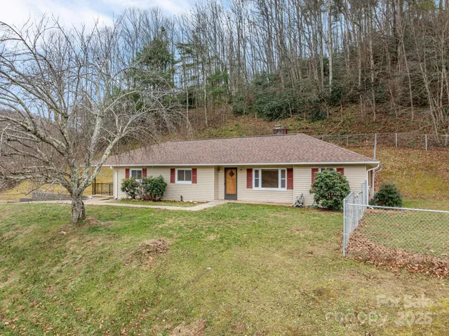 a view of a big house with a big yard and large trees