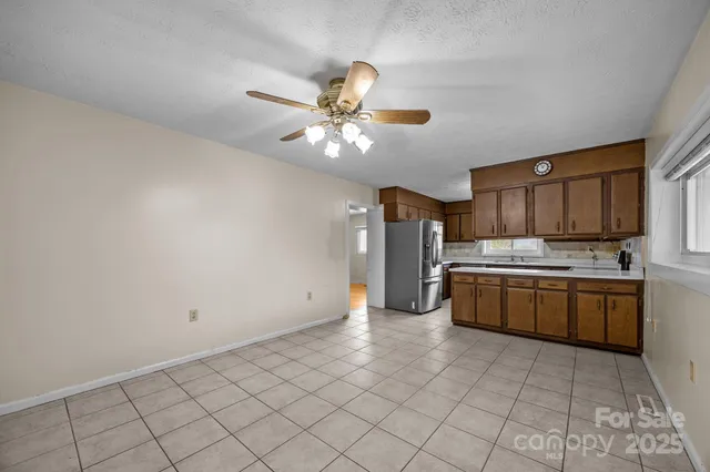 a large kitchen with granite countertop a stove sink and cabinets
