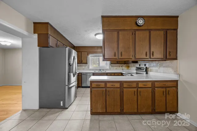 a kitchen with stainless steel appliances granite countertop a refrigerator and a stove
