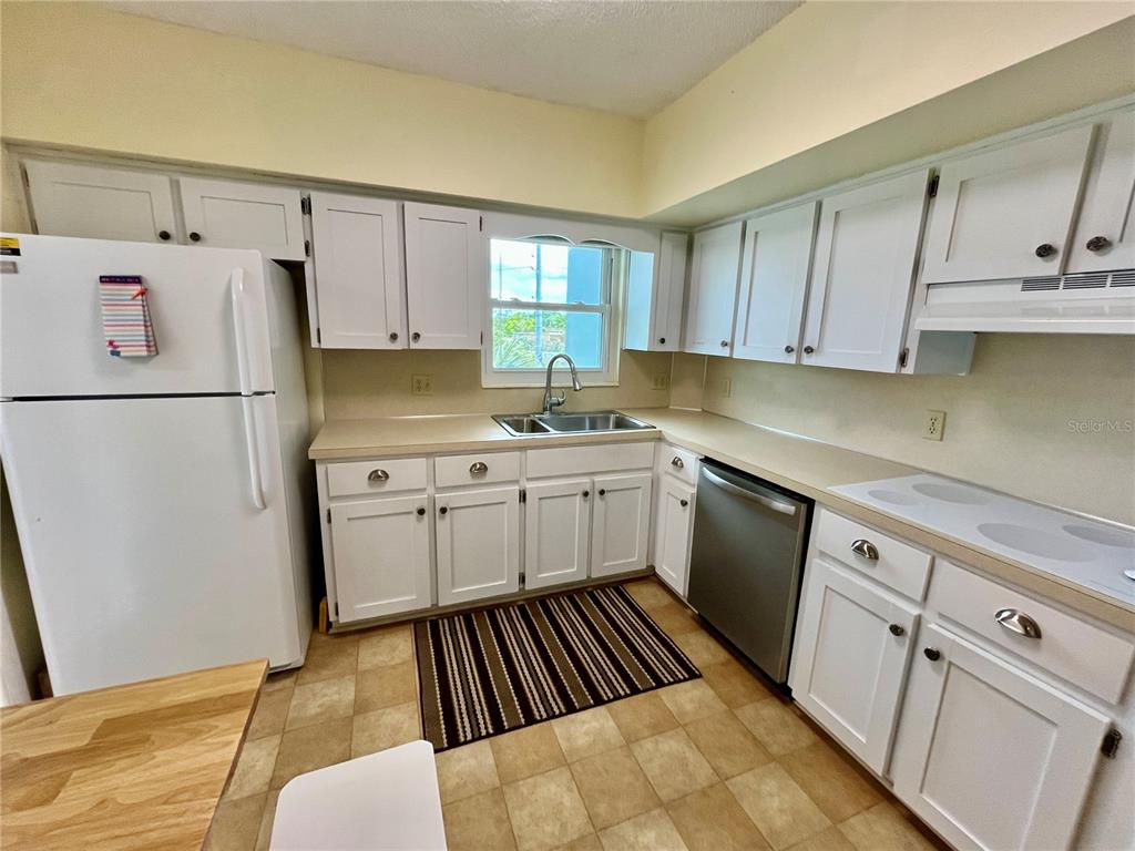 2292 Costa Rican Drive, Unit 22 Clearwater, FL 33763 - Photo 8 of 44 a kitchen with white cabinets and white appliances