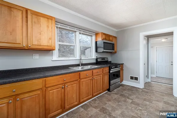 a kitchen with granite countertop a sink and a stove top oven