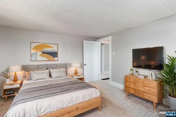 a bedroom with a bed and a painting on the wall
