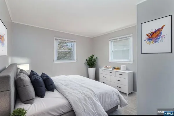 a view of an empty room with closet and wooden floor