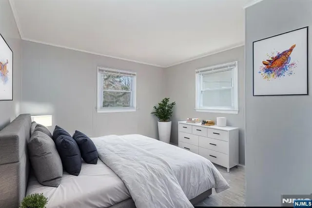 a view of an empty room with closet and wooden floor