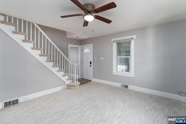 a view of room with window ceiling fan and hardwood floor