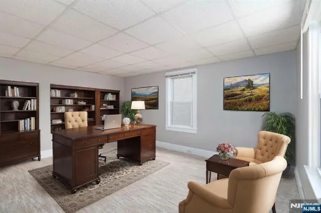 a living room with furniture and paintings on the wall