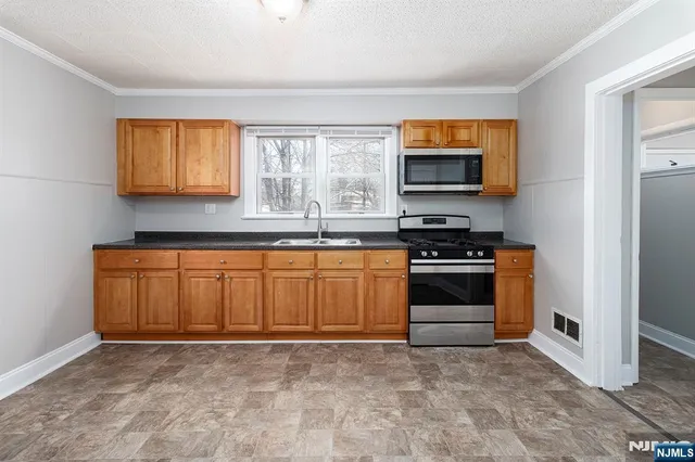a kitchen with granite countertop a stove and a sink