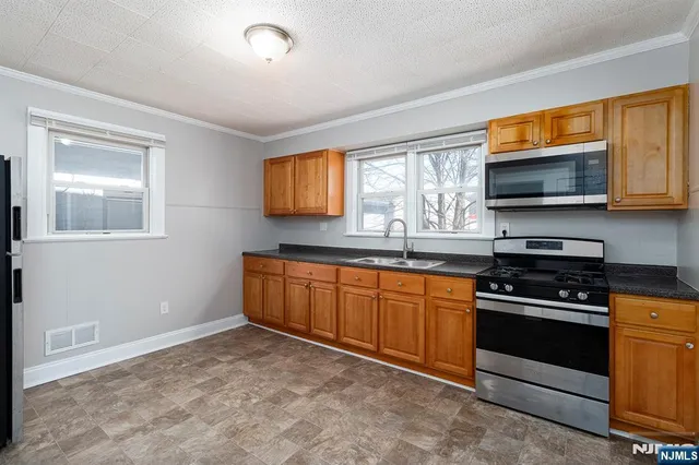 a kitchen with stainless steel appliances granite countertop a stove microwave and sink