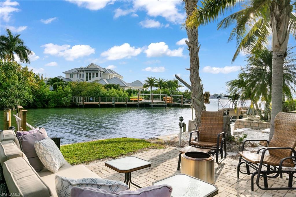 a view of a lake with couches chairs and a yard