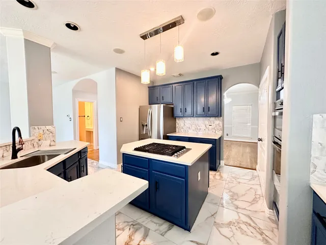 a kitchen with stainless steel appliances granite countertop a sink stove and refrigerator