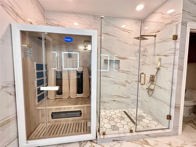 a bathroom with a glass shower door and a window