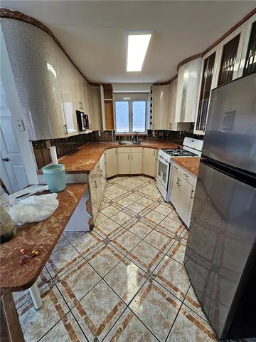 a large white kitchen with stainless steel appliances granite countertop a sink and a stove