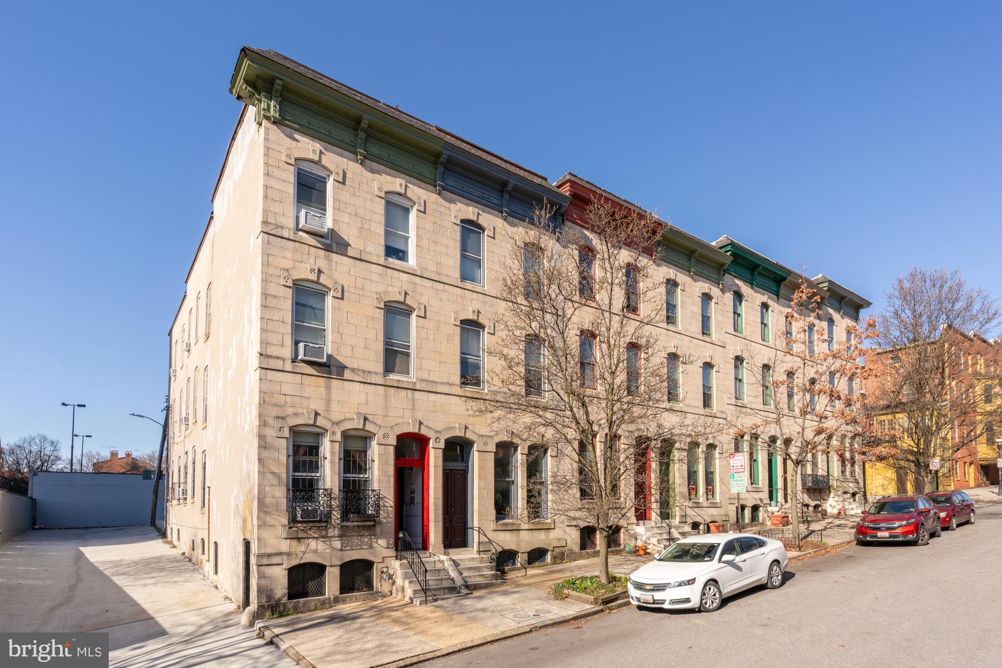 a city street lined with parked cars and buildings
