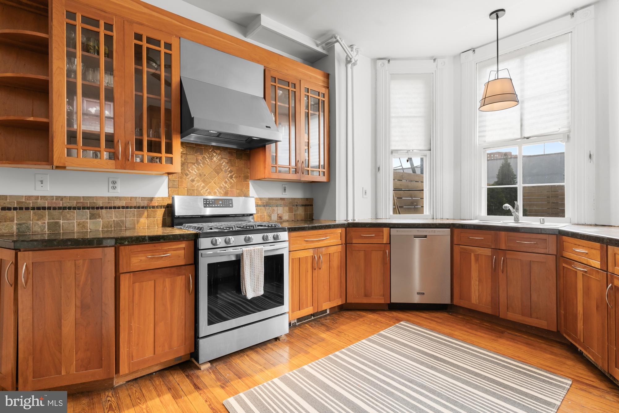 1206 John Street Baltimore, MD 21201 - Photo 20 of 53 a kitchen with stainless steel appliances granite countertop a stove a sink and a microwave