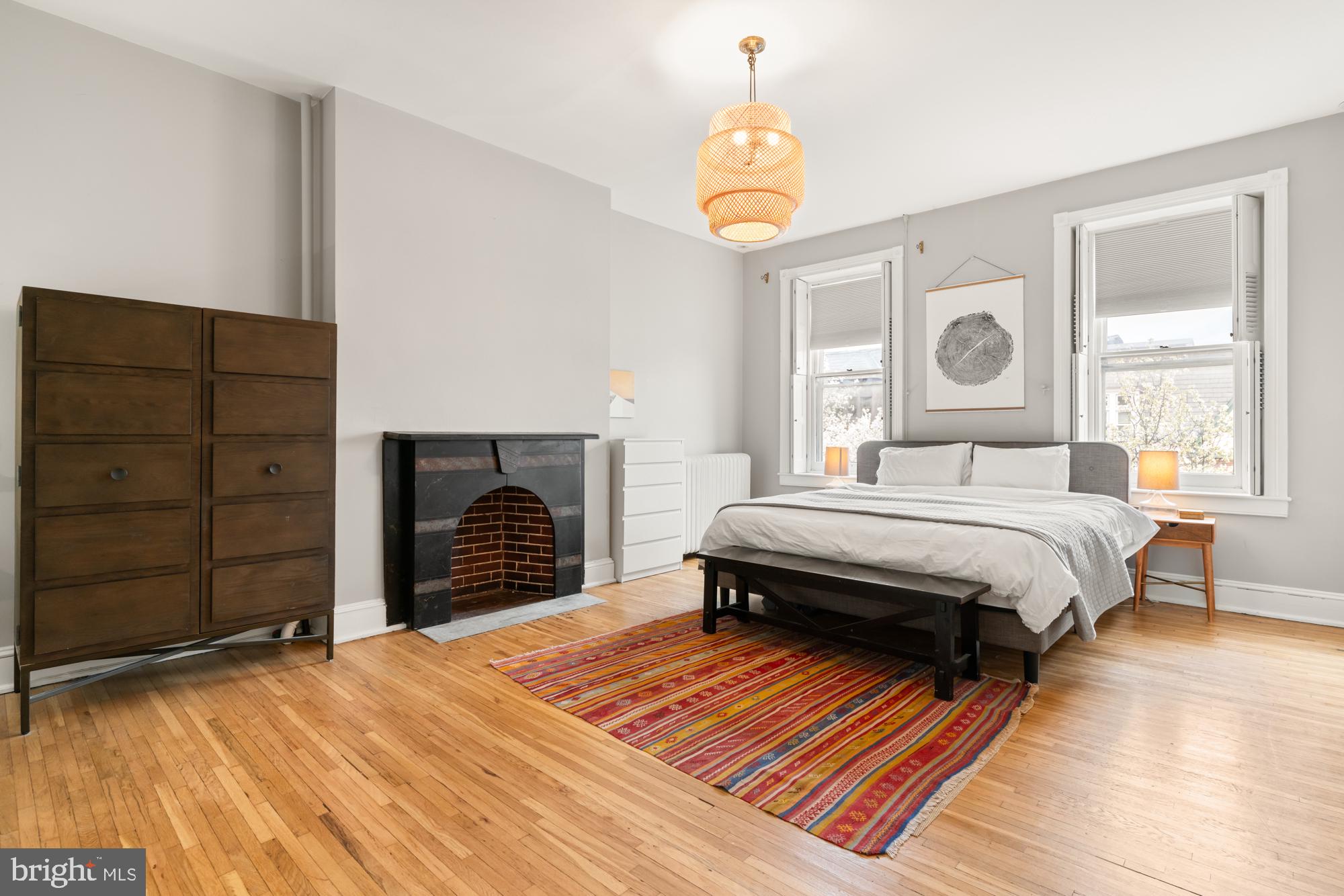 1206 John Street Baltimore, MD 21201 - Photo 35 of 53 a bedroom with a bed and a dresser with wooden floor