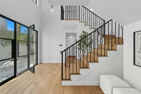 a view of entryway and hall with wooden floor