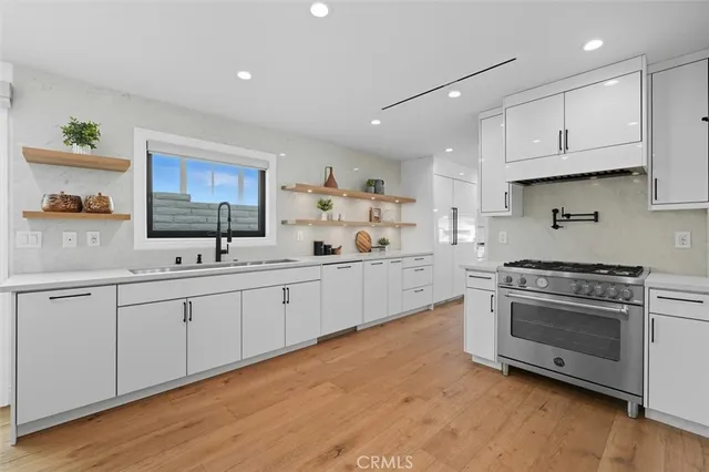 a kitchen with kitchen island a stove a table and chairs in it