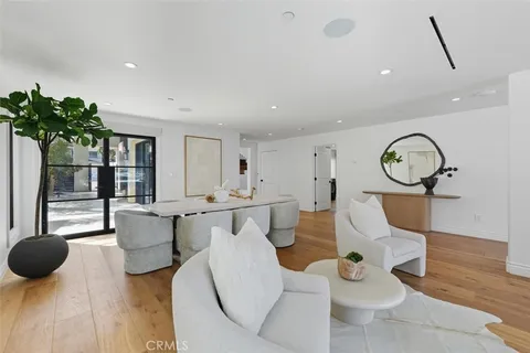 a living room with furniture a chandelier and a large window