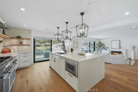 a kitchen with stainless steel appliances a sink stove and wooden floor