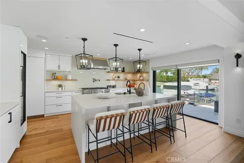 a kitchen with kitchen island a stove a table and chairs in it