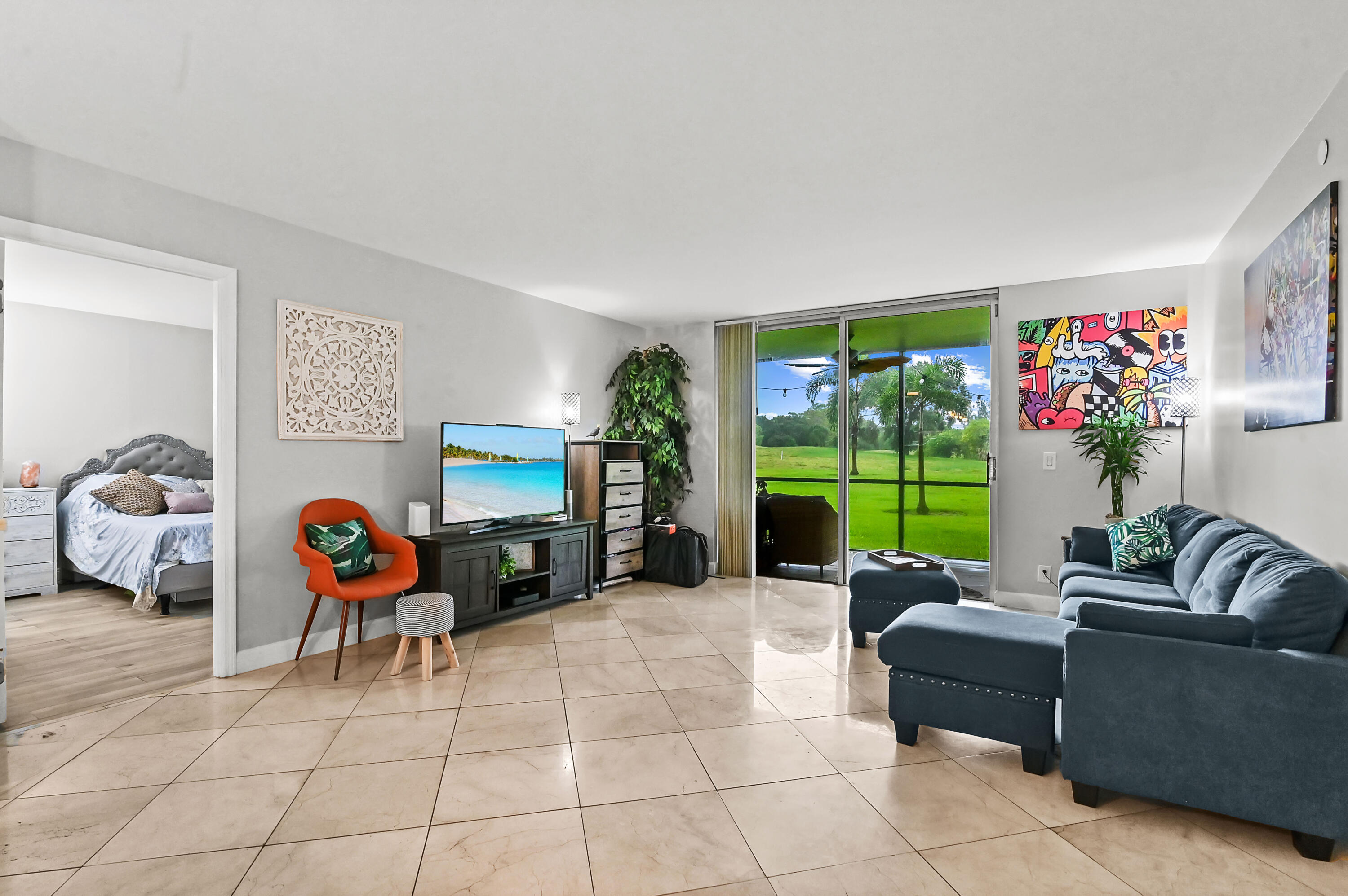 6400 Northwest 2nd Avenue, Unit 124 Boca Raton, FL 33487 - Photo 16 of 33 a living room with furniture a floor to ceiling window and a flat screen tv