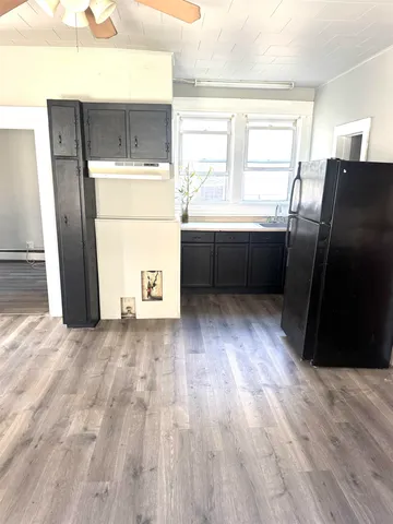 a view of kitchen with a fridge and wooden floor