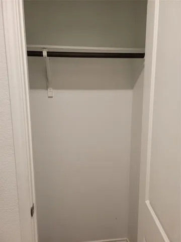 a view of walk in closet with empty racks