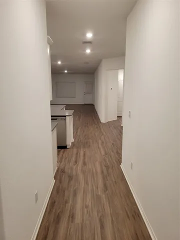 a view of a kitchen with a sink and wooden floor