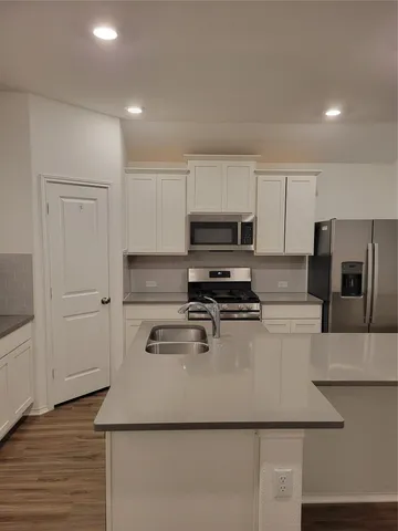 a kitchen with a refrigerator and a stove top oven