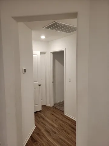 a view of a room with wooden floor and a bathroom