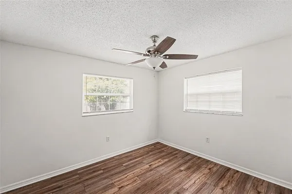 a view of an empty room with a window and a ceiling fan