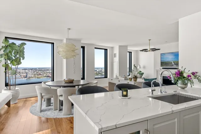 a view of a kitchen with kitchen island granite countertop a sink and a large window