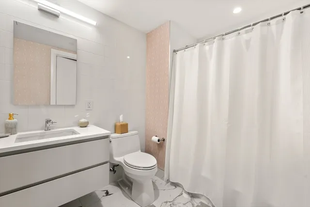 a bathroom with a sink a toilet and a mirror