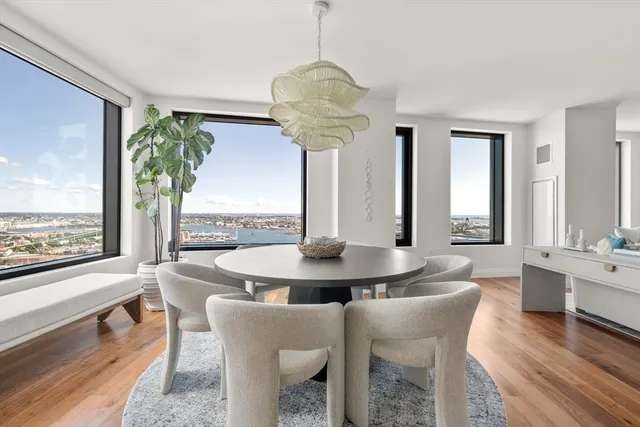 a dining room with furniture a chandelier and wooden floor